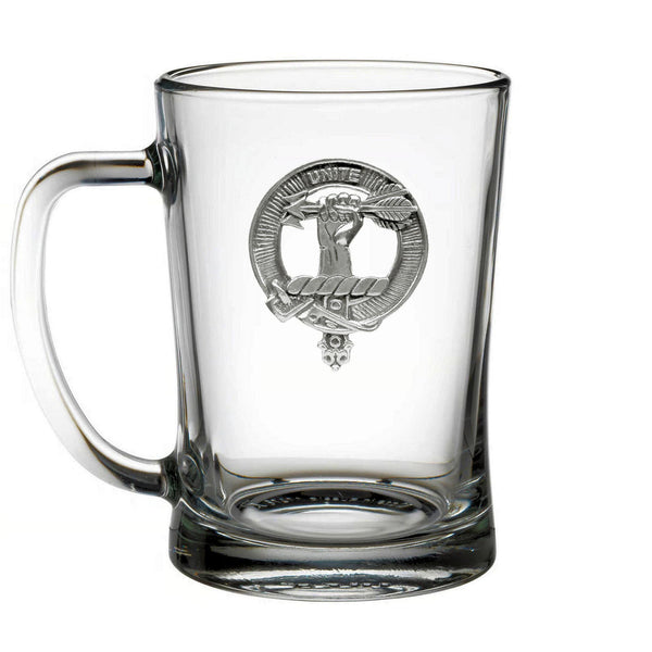A clear glass mug with a silver emblem on it.