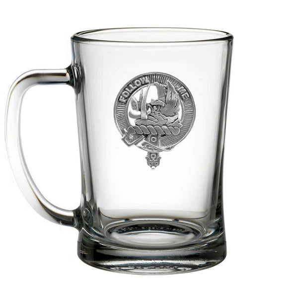 A clear glass mug with an embossed emblem on it.
