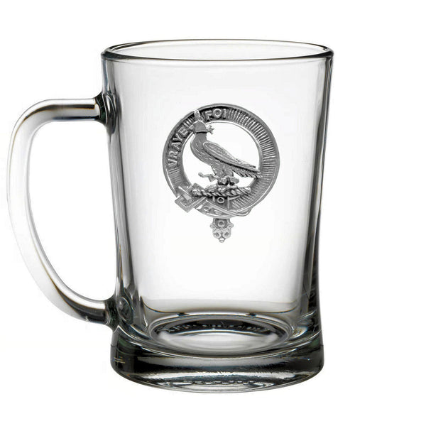 A clear glass mug with a silver emblem featuring a bird and a crest.