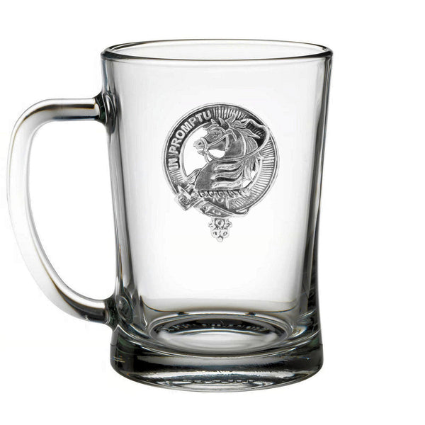 A clear glass mug with an embossed emblem on it.
