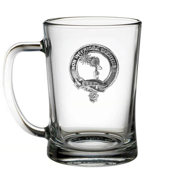 A clear glass mug with an embossed emblem on it.