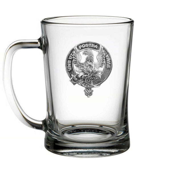 A clear glass mug with an embossed emblem featuring a bird and text.