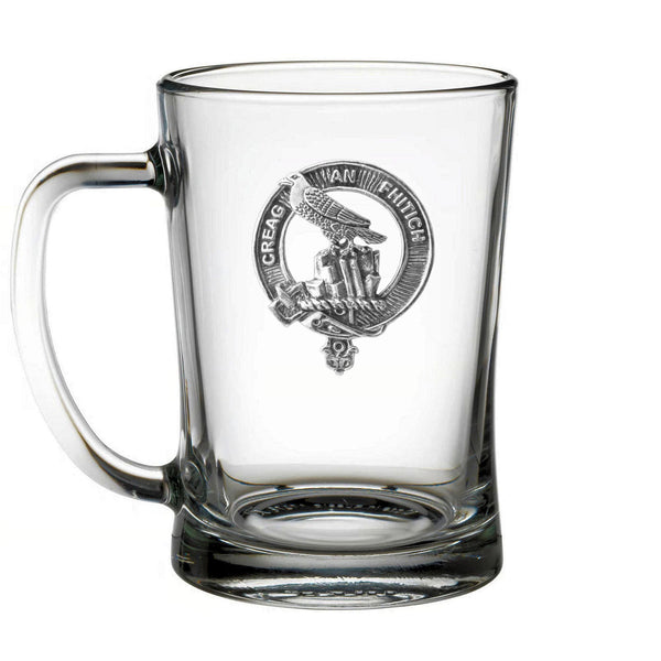A clear glass mug with an embossed emblem on it.