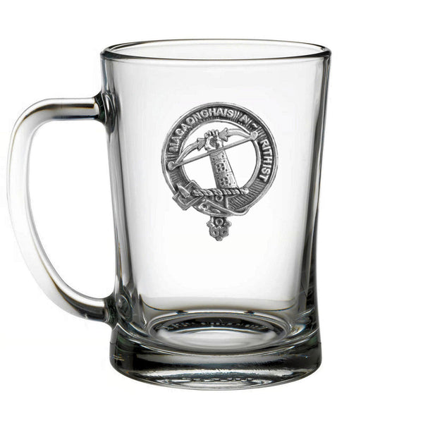 A clear glass mug with an embossed emblem on it.
