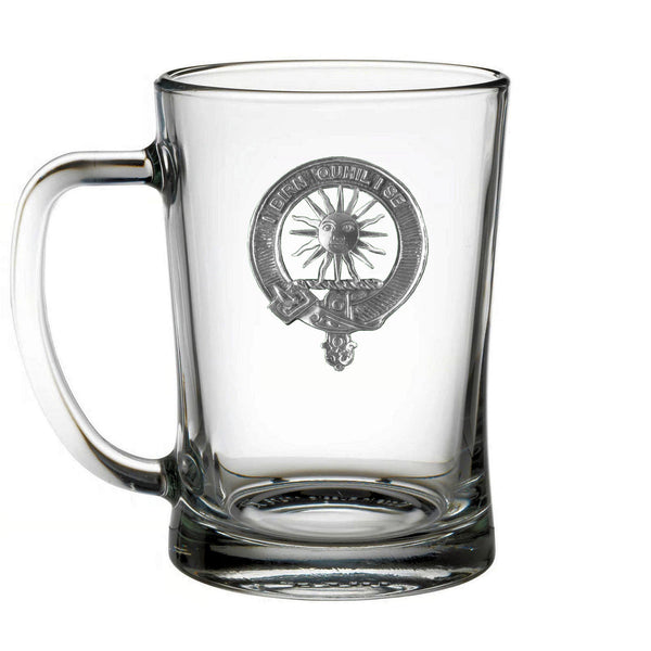 A clear glass mug with an embossed emblem on it.