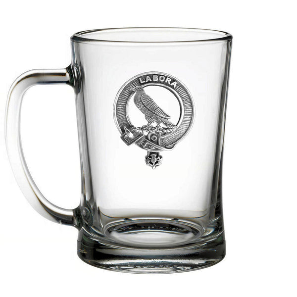A clear glass mug with a metal emblem featuring a bird and the word "LABORA" printed on it.
