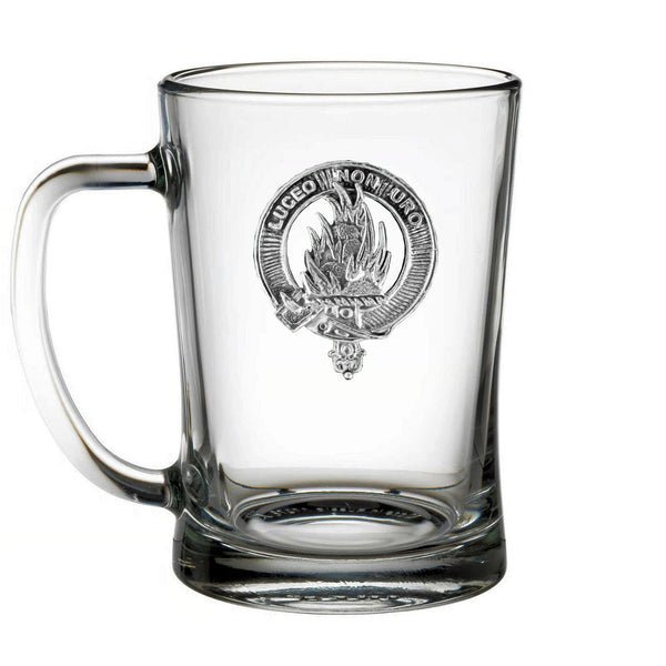 A clear glass mug with an embossed emblem on it.