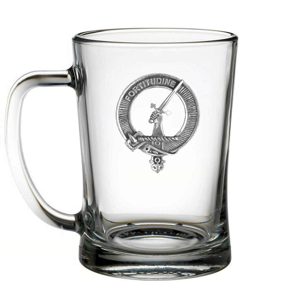 A clear glass mug with an embossed metal emblem featuring a sword and a crown.