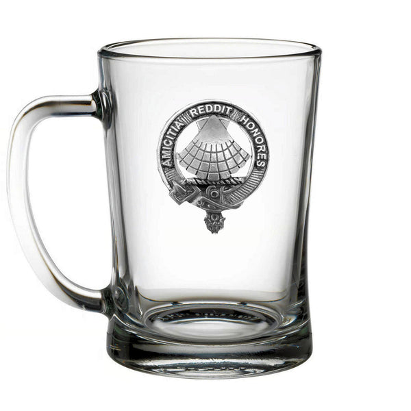 A clear glass mug with a silver emblem on it.
