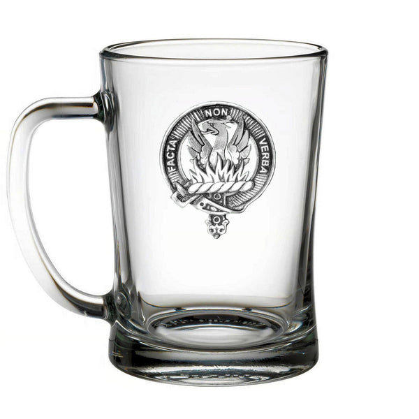 A clear glass mug with an embossed emblem on it.