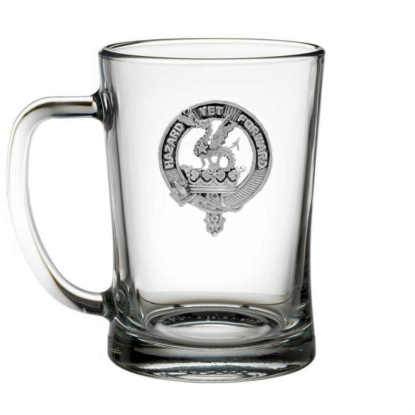 A clear glass mug with an embossed emblem on it.