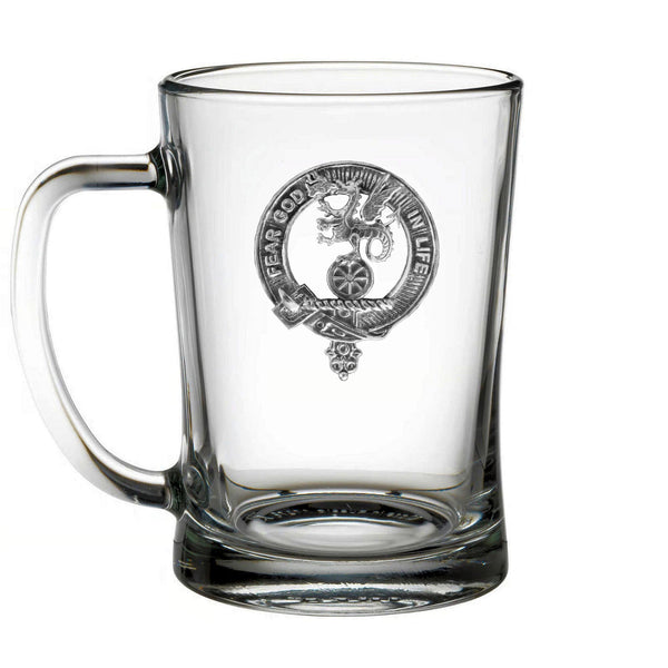 A clear glass mug with an embossed emblem on it.