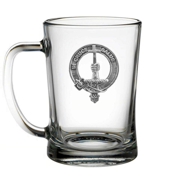A clear glass mug with an embossed emblem on it.