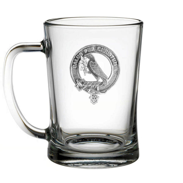 A clear glass mug with an embossed design featuring a bird and a crest.