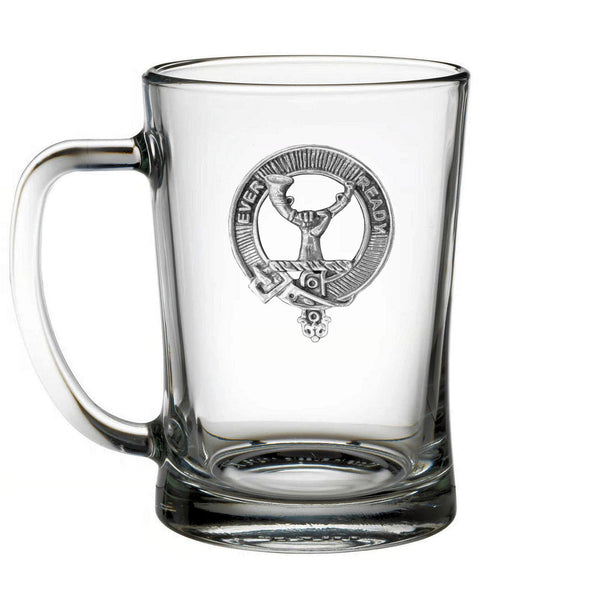 A clear glass mug with an embossed emblem on it.