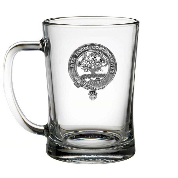 A clear glass mug with an embossed emblem on it.