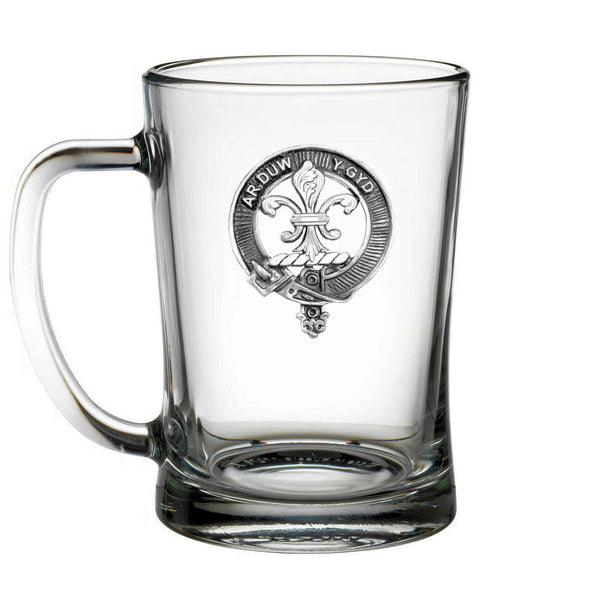 A clear glass mug with a silver emblem on it.