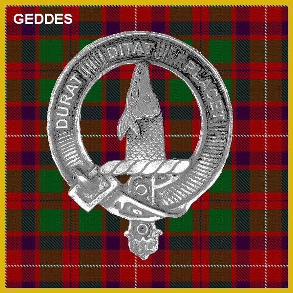 a silver crest or badge with a fish design, set against a background of a red and green plaid pattern.
