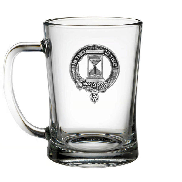 A clear glass mug with an embossed logo featuring a sand timer and the text "In time in time" inside a circular design.