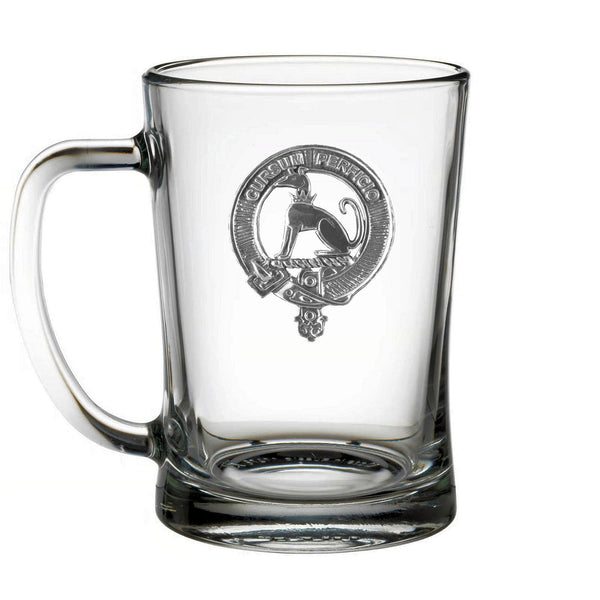 A clear glass mug with an embossed emblem on it.