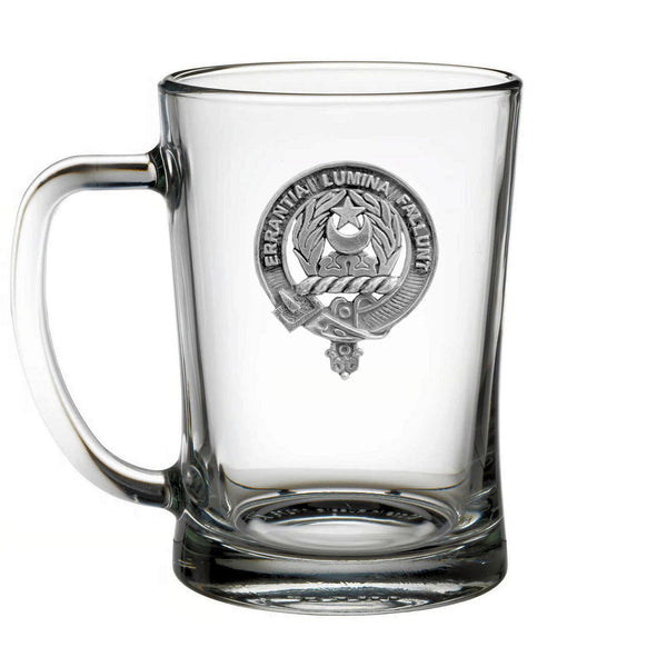 A clear glass mug with an embossed emblem on it.