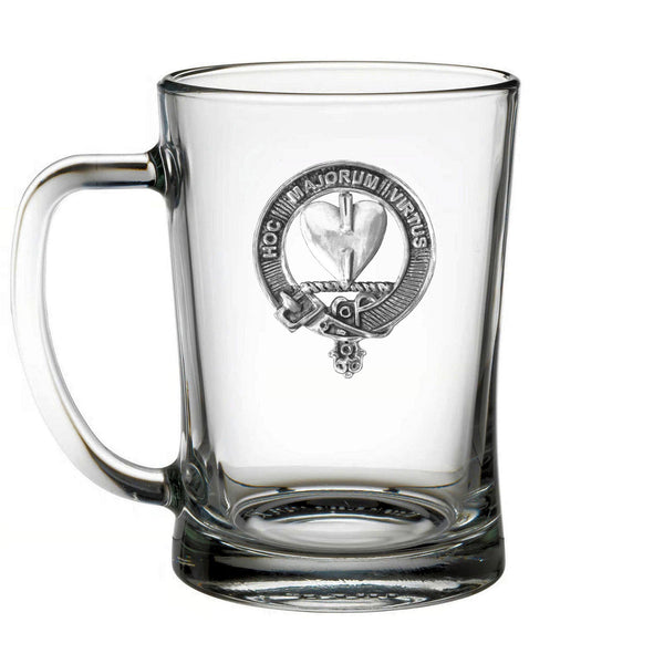 A clear glass mug with a silver emblem on it.