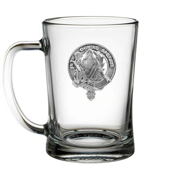 A clear glass mug with an embossed emblem featuring a person in a robe and holding a book.