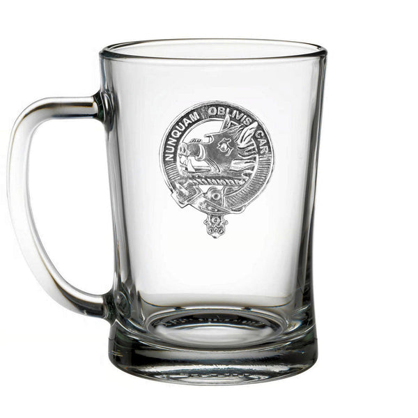 A clear glass mug with an embossed emblem on it.