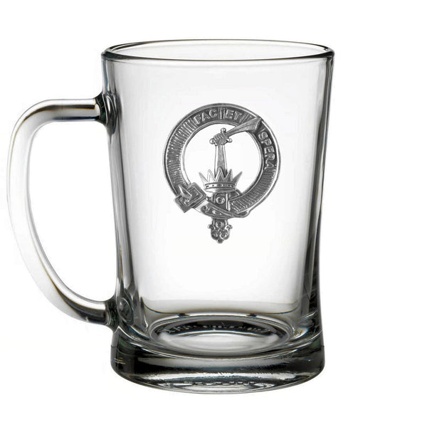 A clear glass mug with an embossed emblem on it.
