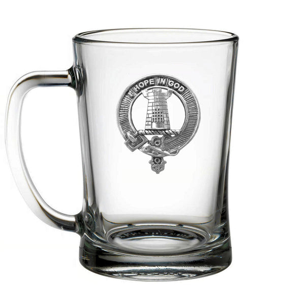 A clear glass mug with an embossed emblem on it.
