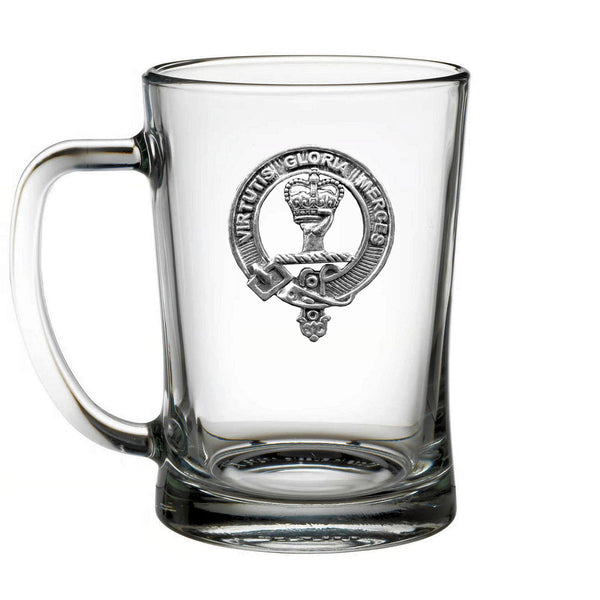 A clear glass mug with an embossed metal emblem on it.