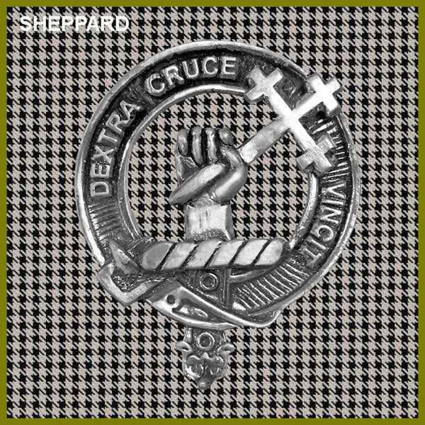 A metal emblem with a cross and a hand, surrounded by a circular design, against a background of a repeating pattern of small squares.