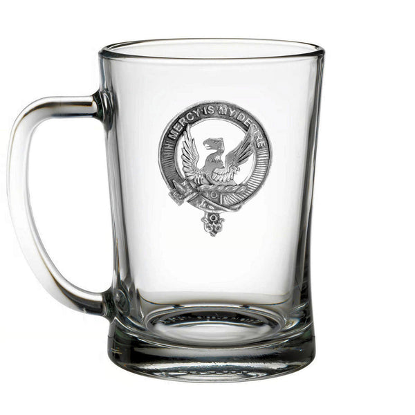 A clear glass mug with an embossed emblem featuring a bird and a shield.