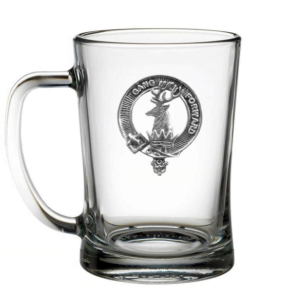 A clear glass mug with an embossed emblem on it.